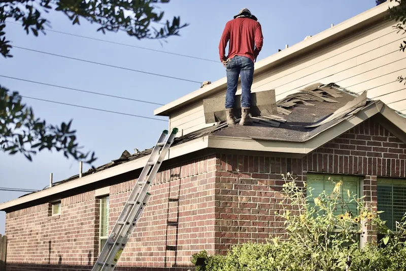 Professional roofer working on a residential roof in Westhampton Beach